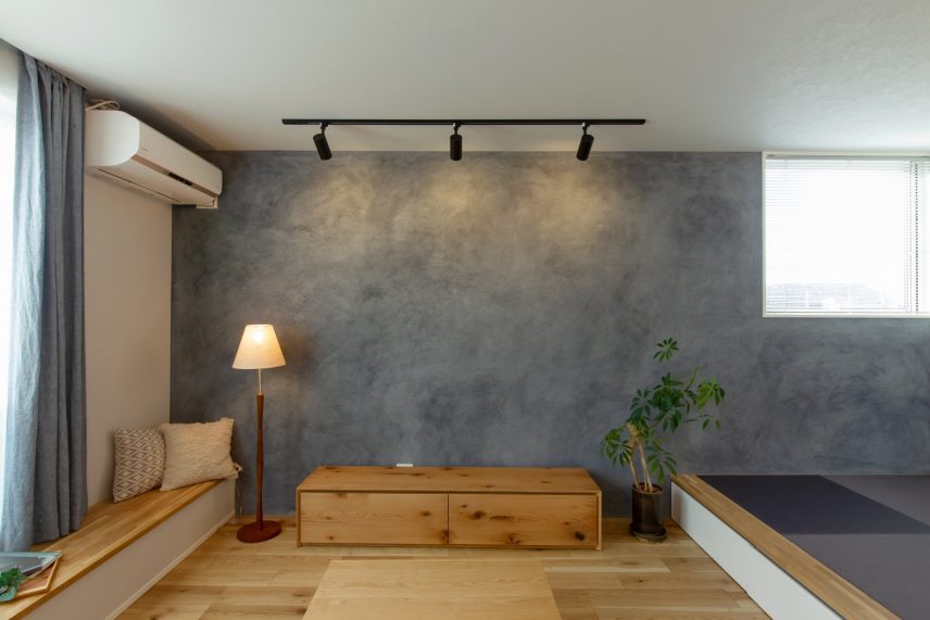 無機質の塗装と無垢の床・家具が調和するリビング