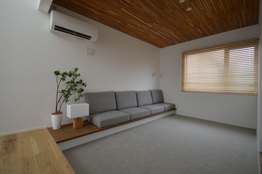【ピットリビング】</br> 木製の材料を天井に並べ、強いアクセントに。</br> ピットリビングとすることで特別感のある空間に。囲われることでこもり感のある、安心する空間になります。</br> 造作ソファで家具の位置決定、カーペット敷の床仕上げで広く使えます。</br>