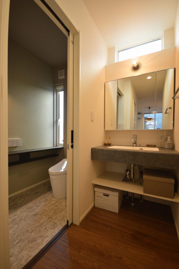 LDKと直結する洗面スペースとトイレ空間。モルタル調のシンクでインテリア性UP。