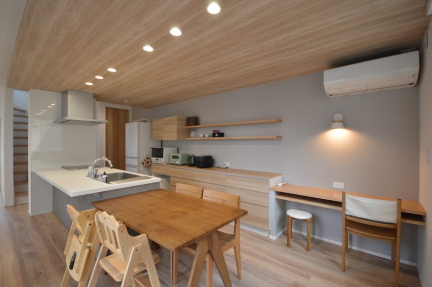 木目クロスの天井フラット対面キッチンがインテリアになるダイニングキッチン。