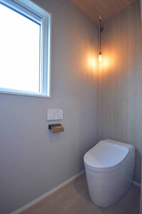 木目クロスとフィラメント照明がおしゃれなトイレ。