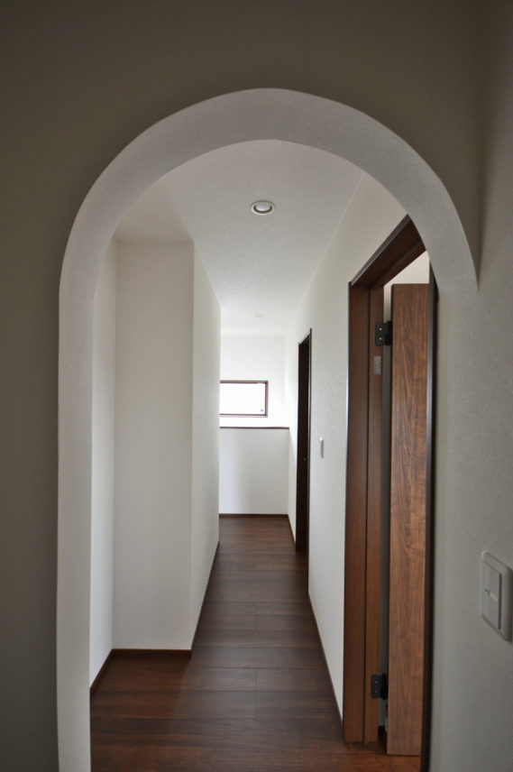 2階ホールの納戸の入口はアーチ下がり壁でデザインをつけた。