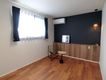 ■濃紺＆木目調のクロスで個性を演出した６帖の寝室