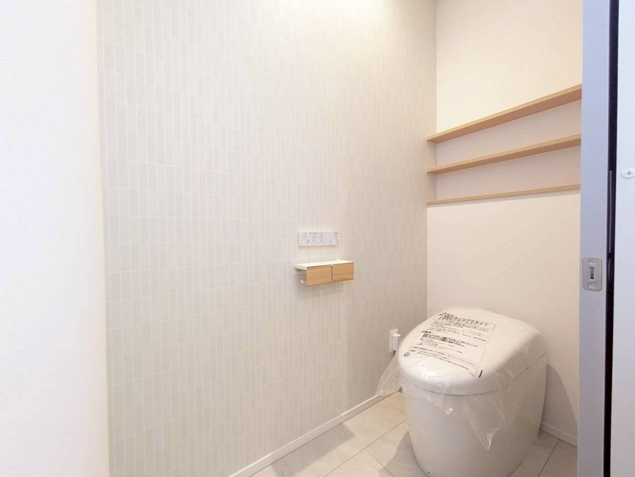 ■１階トイレ　
＿タンクレスですっきり、造作棚とアクセントクロスが映えるトイレ空間。