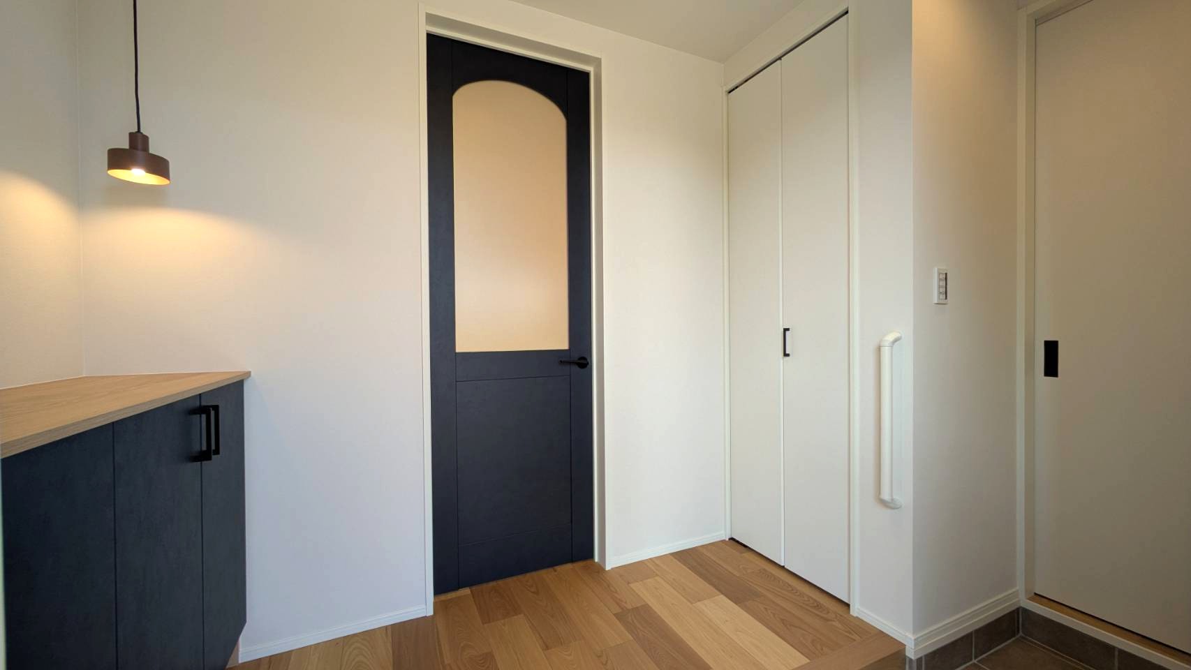 玄関・ホール－
リビングのガラスドアとペンダントライトがおしゃれな玄関。玄関→パントリーへ直接アクセスできるのでお買い物後の片付けがラクラク♪コート掛けや土間収納も備え付けられている。