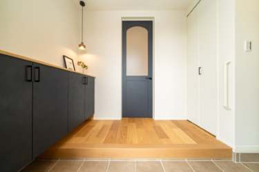 ■玄関（ホール側）
リビングのガラスドアとペンダントライトがおしゃれな玄関。玄関→パントリーへ直接アクセスできるのでお買い物後の片付けがラクラク♪コート掛けや土間収納も備え付けられている。