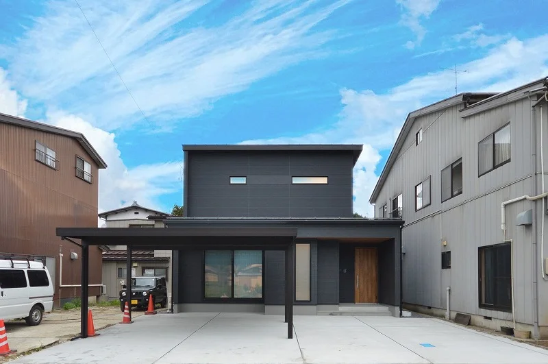 黒い外壁に映える木目調の玄関