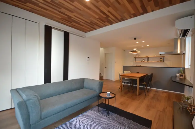 天井板張り風のリアルなクロスで印象的に。天井高2.6ｍの開放的なリビング。