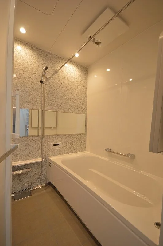 大きなバスタブと明るいダウンライトを設置したバスルーム