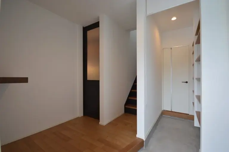 玄関には大容量のシューズクローク、リビングへの扉は背の高さが際立つ