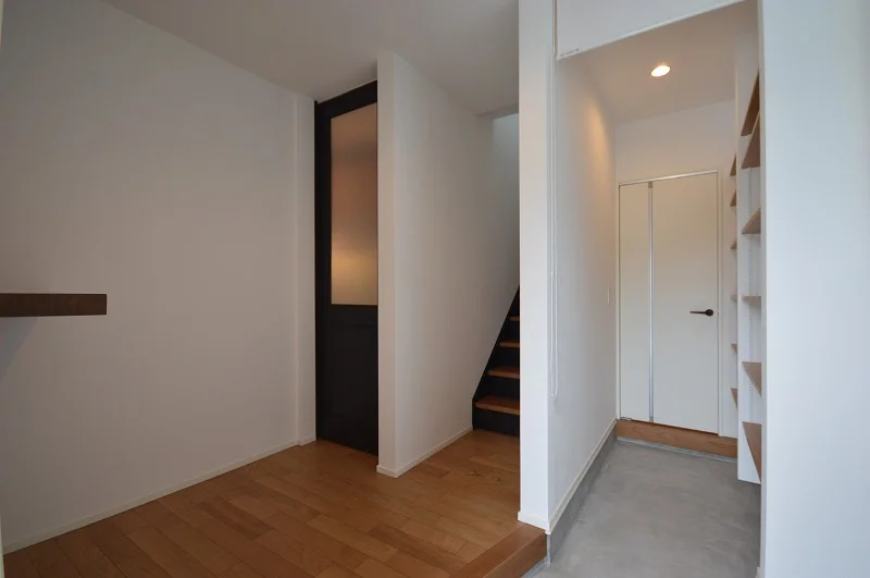 玄関には大容量のシューズクローク、リビングへの扉は背の高さが際立つ