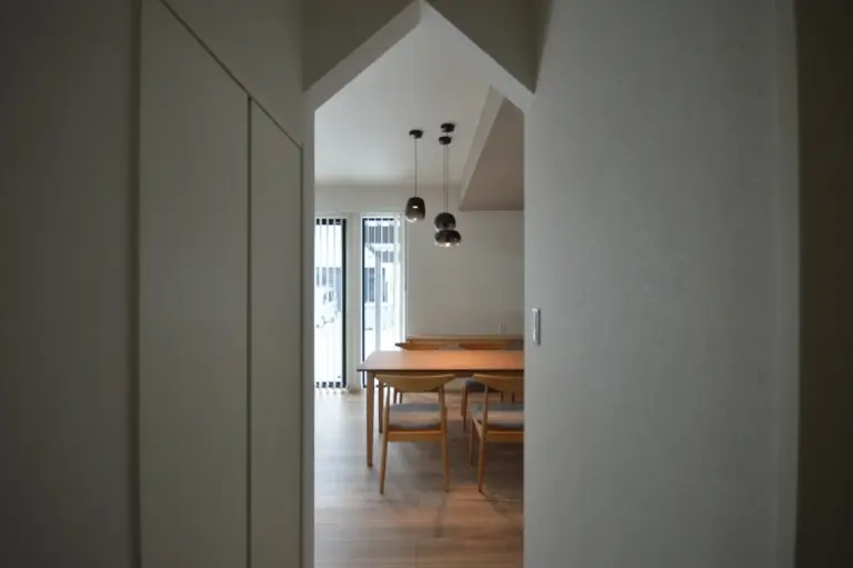 プライベート動線からダイニングのおしゃれな照明器具が見える。