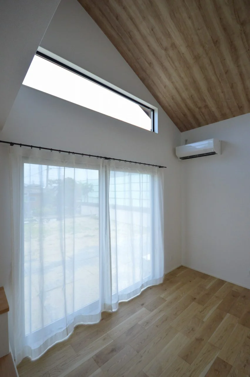 【リビング】 勾配天井で開放的に。 北向きリビングながら、大開口と部屋の高さを活かした窓で明るい空間に。