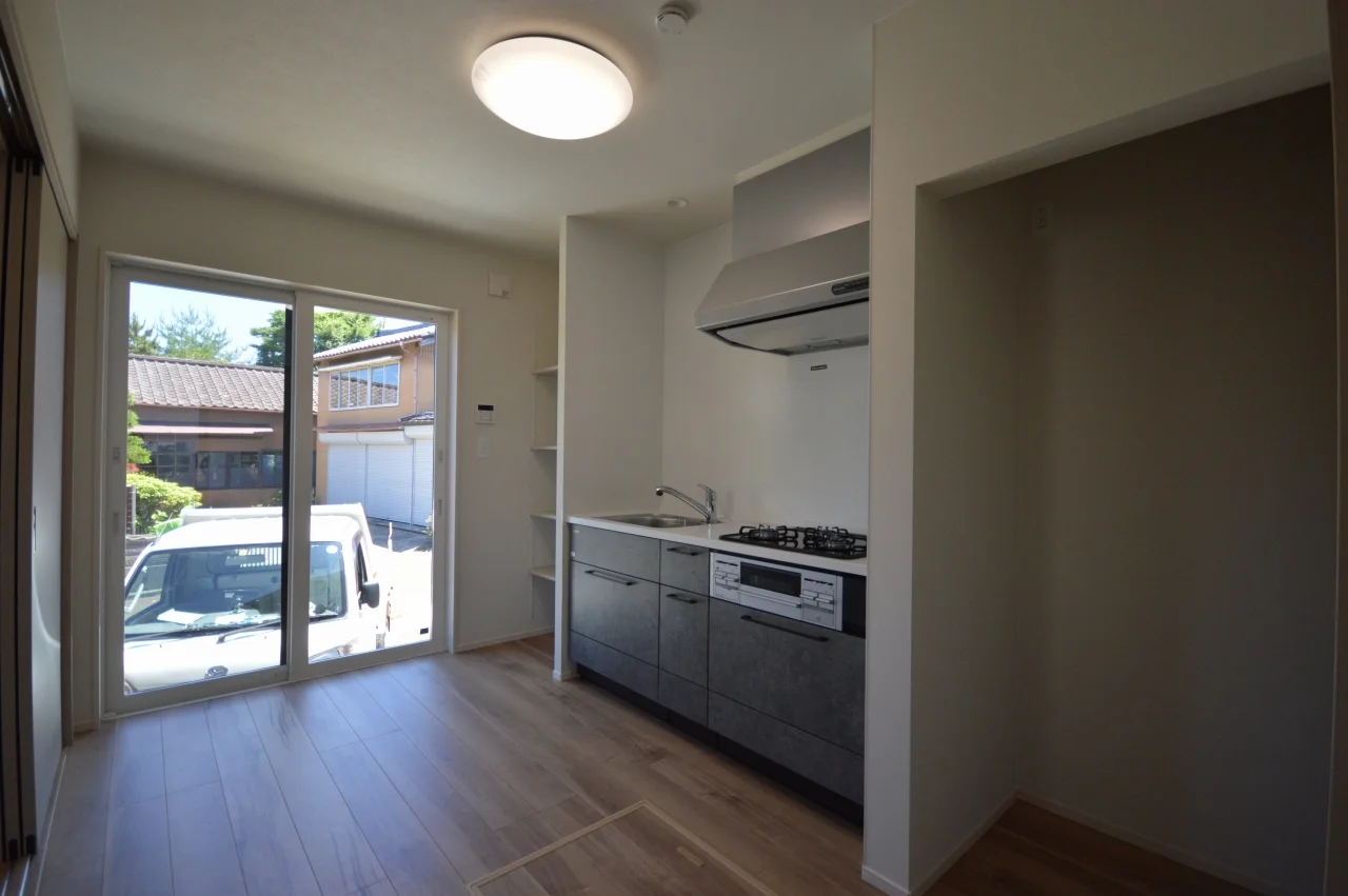 親世帯のコンパクトなダイニングキッチン。システムキッチンもミニキッチンで。