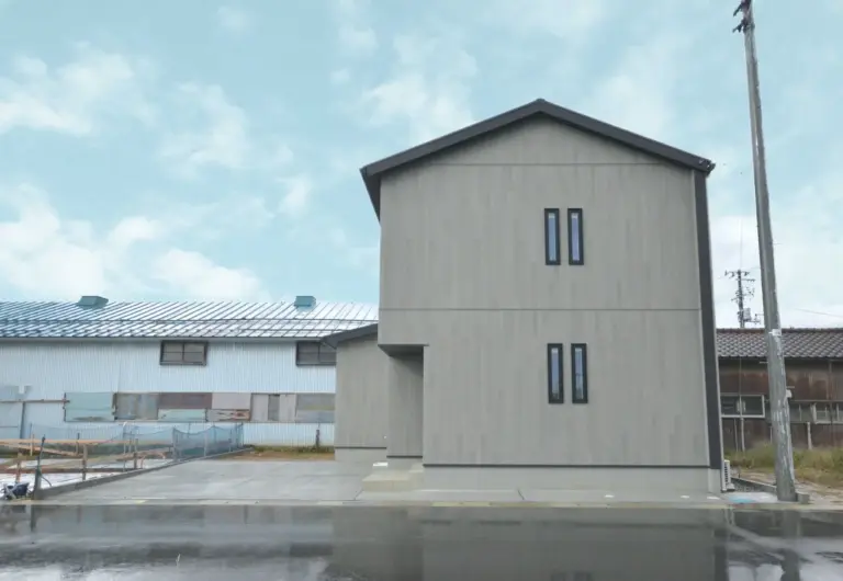 三角屋根の家らしい外観。 黒い屋根が壁まで繋がるデザインで個性をプラス。 外壁は縦張りでグレーの木目を使用し、汚れの目立ちにくい印象に。