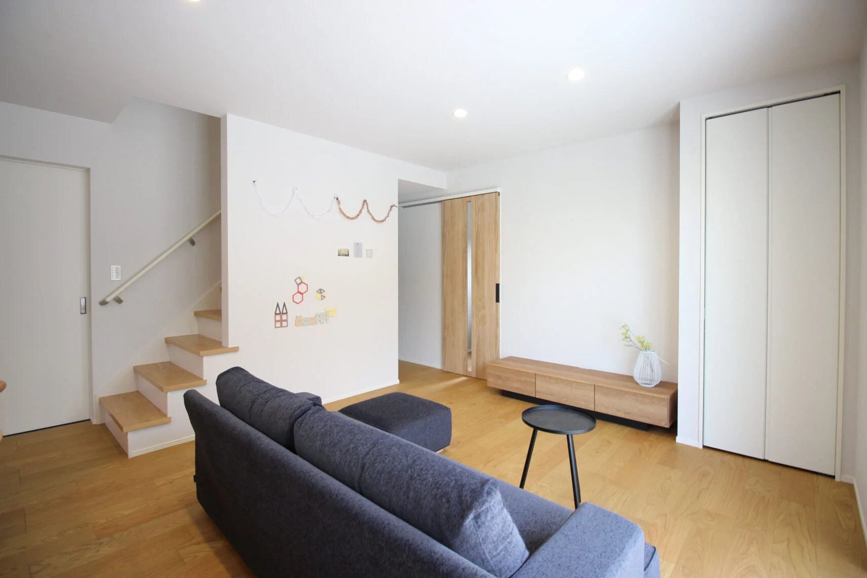 【リビング１】階段横の広い壁は飾れる壁面に。お誕生日など飾りつけをして記念写真などに活用できます。