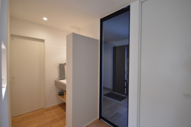 玄関ホールから洗面スペースへ
＿スムーズに移動できる動線。光をたっぷり取り込むガラスドアで、明るい空間に。