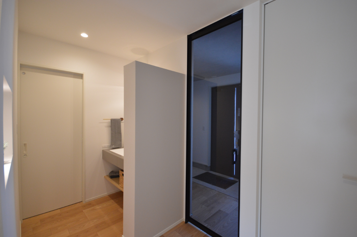 玄関ホールから洗面スペースへ
＿スムーズに移動できる動線。光をたっぷり取り込むガラスドアで、明るい空間に。