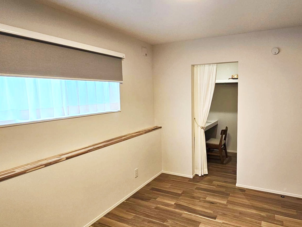 入口をカーテンで仕切ったウォークインクローゼット内には、作業ができるデスクスペースを設け、限られた広さを多目的に活用